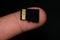 Microsd card on human finger over black background,hi tech data storage devices