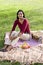 Mid-adult Indian woman sitting on picnic blanket