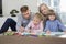 Mid adult parents with children drawing together at home