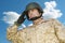 Mid-adult soldier in military uniform saluting against cloudy sky