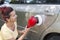 Mid aged cute woman polishing her car