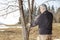 Mid aged man gardener sawing, cutting fruit tree