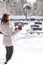 Mid aged woman with candle on snowy cemetery