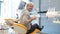 A mid aged young handsome man sitting in a dentists chair, he turns smiles into camera and shows a thumb up