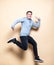 Mid-air shot of cheerful, successful, lucky teenager guy in casual outfit jumping with smile, hands up, triumphant, gesturing