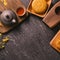 Mid-Autumn Festival traditional food concept - Beautiful Moon cake on black slate table with tea, pastry mold, flower, top view,