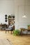 Mid-century modern armchair in a gray living room interior with wooden furniture, workspace and vintage decor. Real photo.