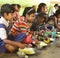 Mid day meal program, an Indian government initiative, is being running in a primary school. Pupils are taking their meal