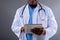 Mid section of african american male doctor using digital tablet against grey background