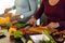 Mid section of biracial lesbian couple chopping vegetables in kitchen