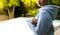 Mid section of biracial woman wearing gray hoodie over swimming pool in garden