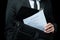 Mid section of businessman in suit holding briefcase with papers