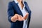 Mid section of businesswoman with cupped hand against grey background