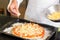 Mid section of a chef preparing pizza