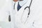 Mid section of doctor in lab coat and with stethoscope