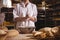 Mid-section of female baker spreading flour in a bowl