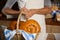 Mid-section of female staff holding wicker basket of breads at counter