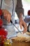 Mid section of female staff slicing cheese at counter