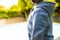 Mid section of happy biracial woman wearing gray hoodie over swimming pool in garden