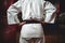 Mid section of karate player with hands on hips