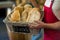 Mid section of male staff holding a basket of baguettes at counter