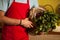 Mid section of male staff holding leafy vegetables in basket at organic section