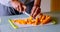 Mid section of man cutting slice of carrot in kitchen 4k