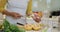 Mid section of mixed race woman preparing healthy drink, cutting fruit and vegetables in kitchen