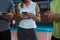 Mid section of players using phones at volleyball court