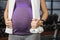 Mid section of pregnant woman standing