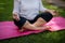 Mid section of senior woman meditating on exercise mat