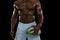 Mid section of shirtless male athlete holding rugby ball