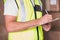 Mid section of warehouse worker with clipboard