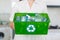 Mid section of woman carrying box with recycling symbol