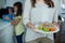 Mid-section of woman holding a plate of cupcakes