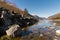 Midday Autumn landscape calm river in the Caucasus Mountains with rocks in the near term