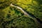 Midday Serenity: A Drones View of a Vast Green Meadow and Winding River