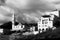 Midday urban view of a church and an interesting architecture house with four floors, balconies and arches, under a cloudy sky, in