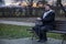 Middle adult calm bearded man sitting on bench lonely melancholy mood in autumn park dray ordinary day