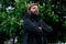 Middle adult man portrait with beard posing photography foreshortening from below on outside park space environment unfocused