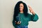 Middle age african american woman holding oil motor bottle doing ok sign with fingers, smiling friendly gesturing excellent symbol