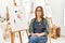 Middle age artist woman at art studio skeptic and nervous, frowning upset because of problem