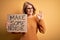 Middle age beautiful blonde activist woman holding banner with make some noise message doing ok sign with fingers, excellent