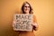 Middle age beautiful blonde activist woman holding banner with make some noise message with a happy face standing and smiling with