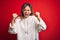 Middle age beautiful sportswoman wearing casual sweatshirt over isolated red background angry and mad raising fists frustrated and