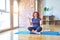 Middle age beautiful sportswoman wearing sportswear sitting on mat practicing yoga at home crazy and mad shouting and yelling with