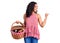Middle age beautiful woman holding picnic basket with food pointing thumb up to the side smiling happy with open mouth