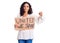 Middle age beautiful woman holding united we stand banner with angry face, negative sign showing dislike with thumbs down,