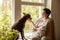 Middle age beautiful woman sitting on windowsill with her dog. 50-year-old woman spending time with her Mexican hairless