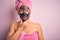 Middle age brunette woman wearing beauty black face mask over isolated pink background Looking fascinated with disbelief, surprise